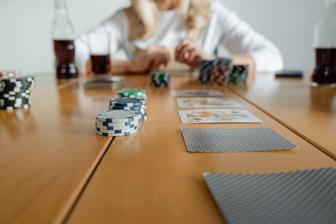 about-us Close-up of poker chips and cards on a table during a casual game session indoors.